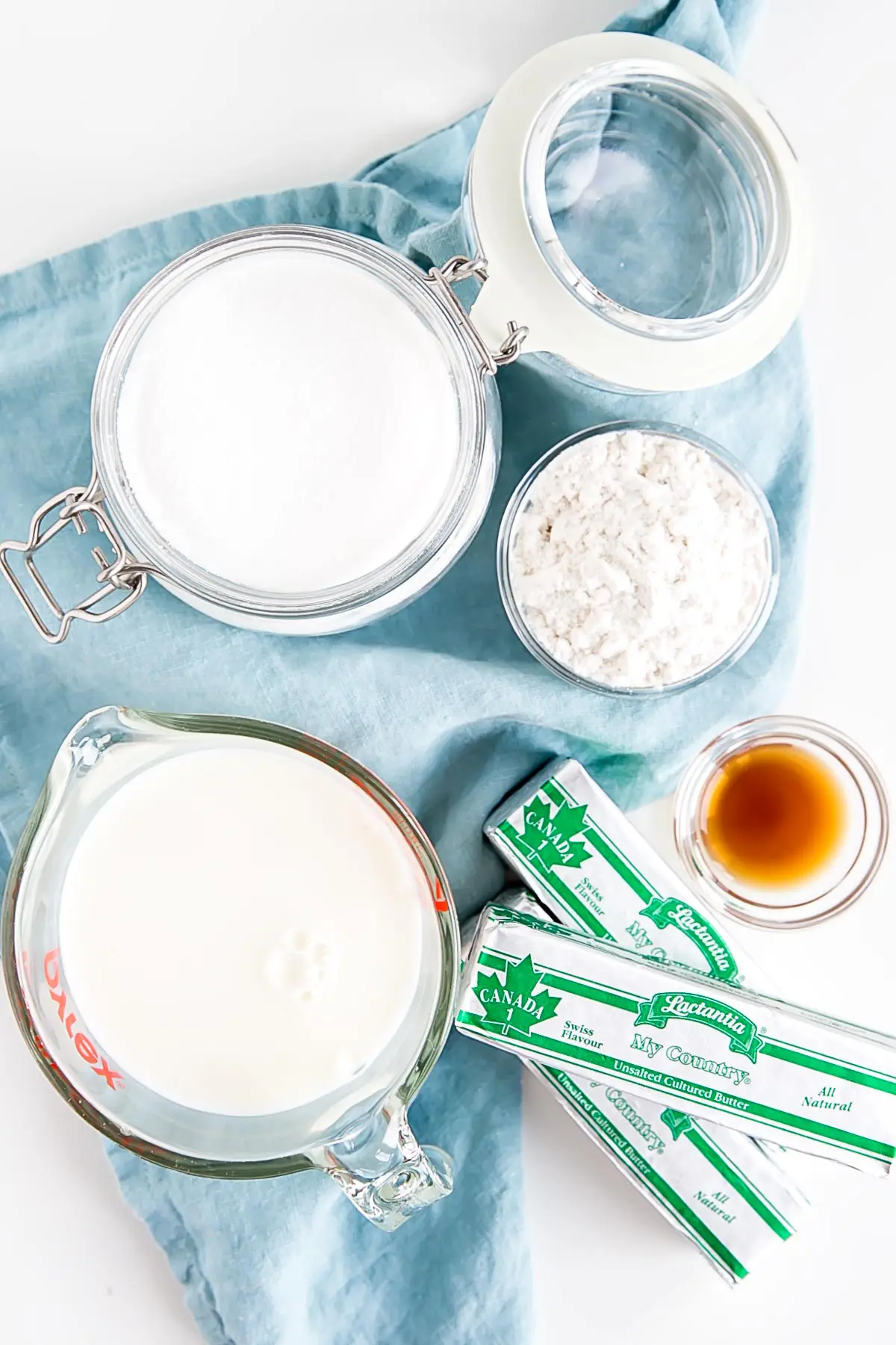 Ingredients shown against a blue tea towel -- milk, sugar, flour, butter, and vanilla.