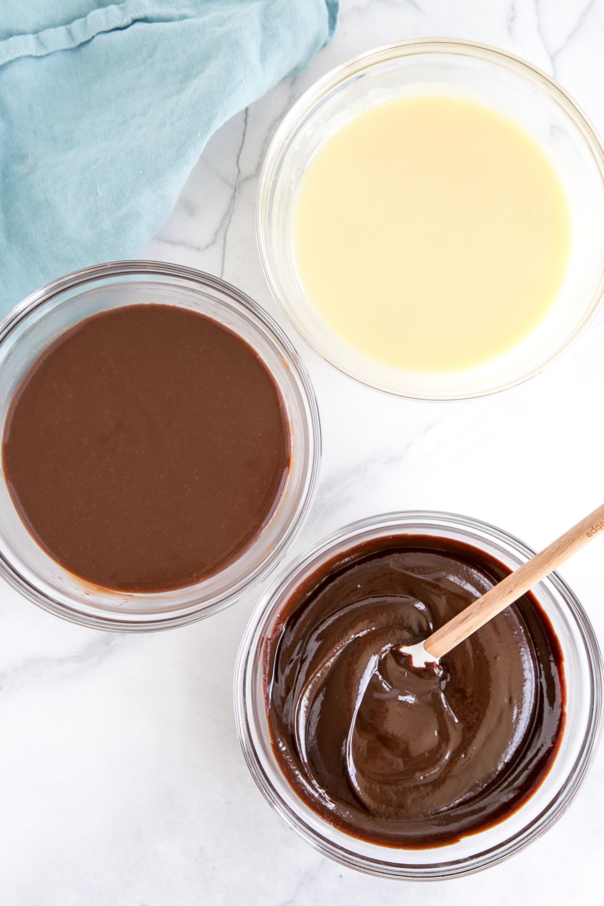 Three bowls of ganache -- white, milk, and dark.