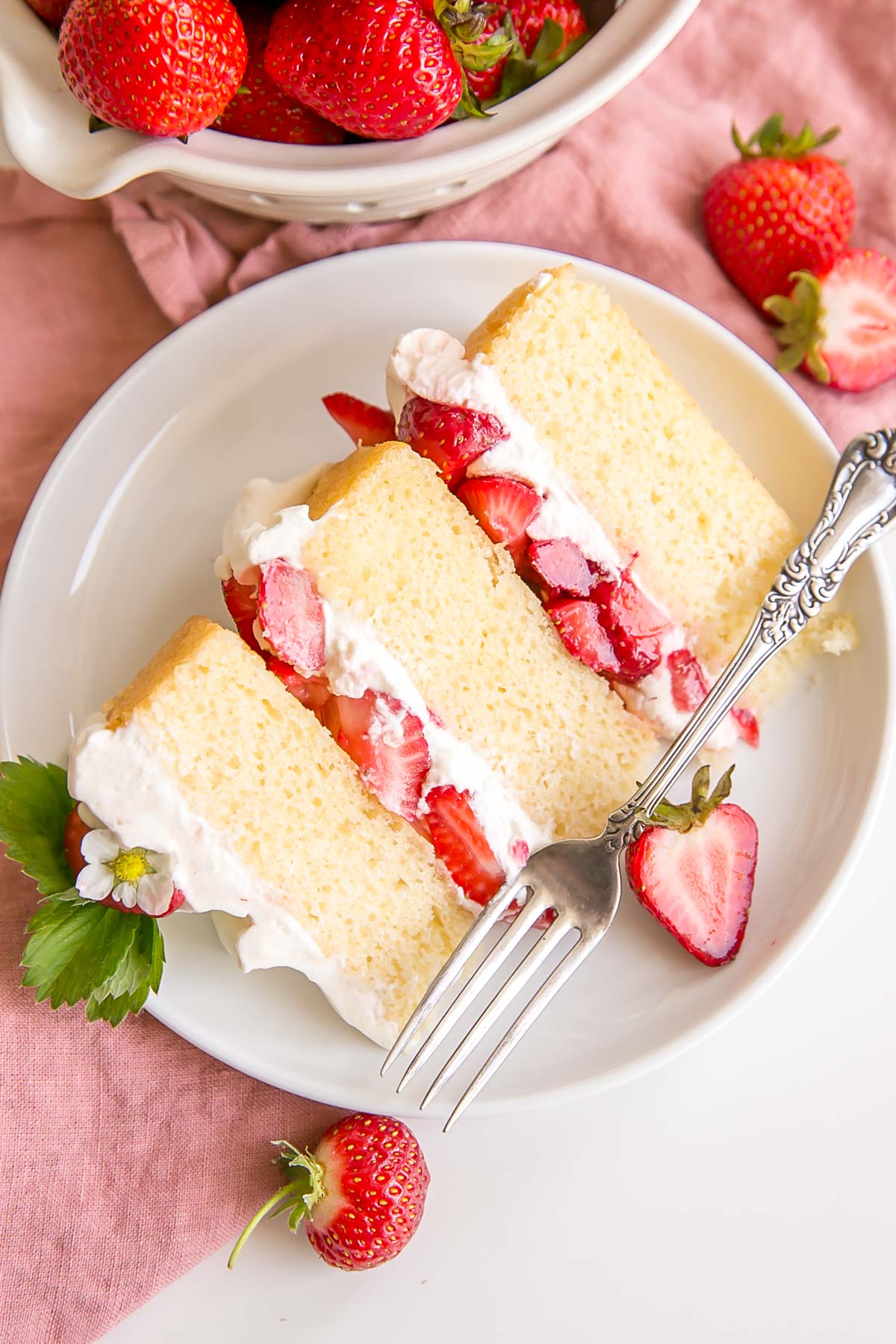 Slice of strawberry shortcake cake on a plate.