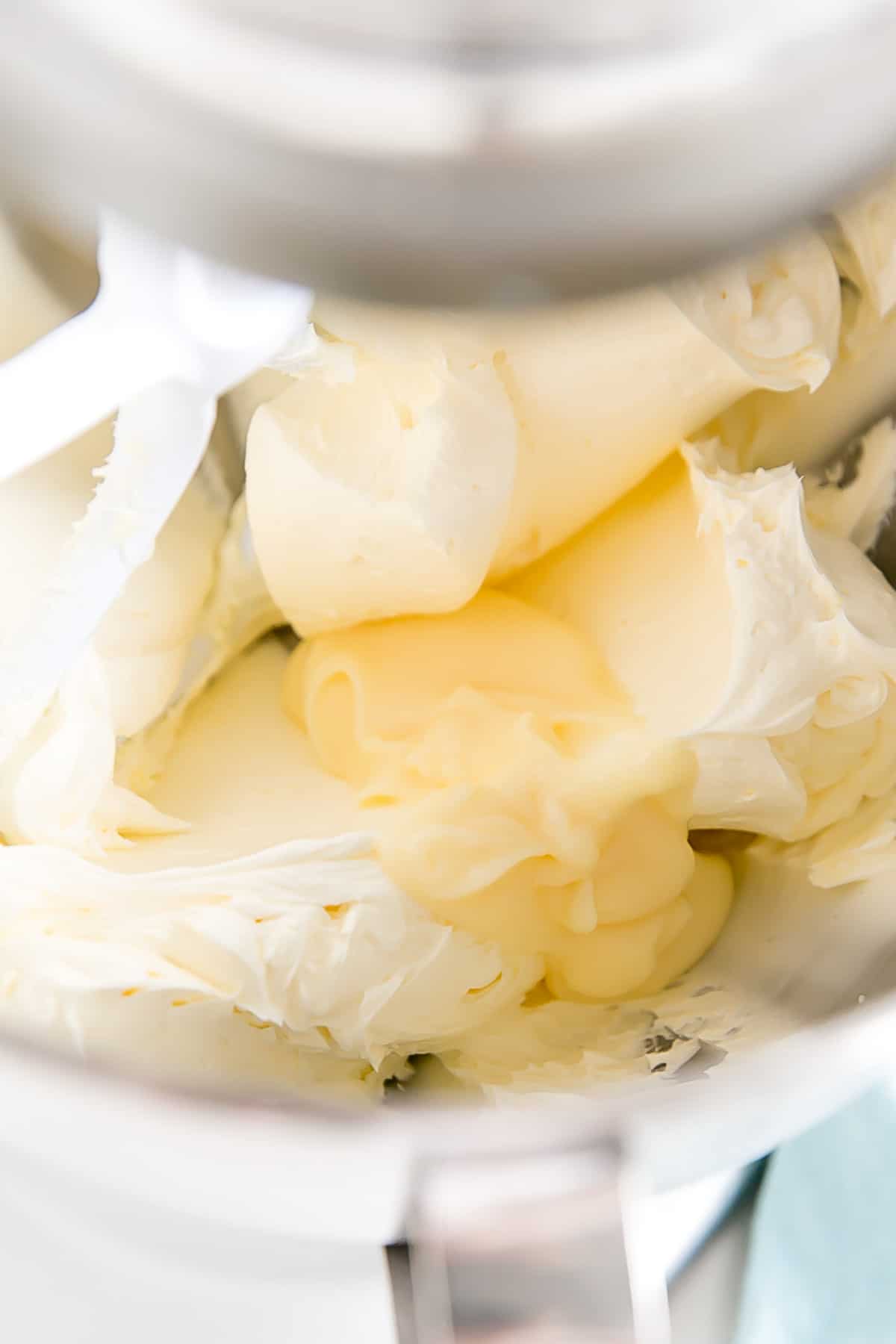 Adding pastry cream to whipped butter.