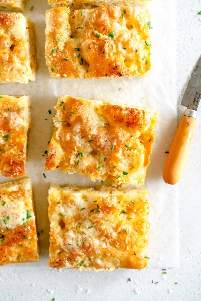 Baked garlic bread on wax paper with knife
